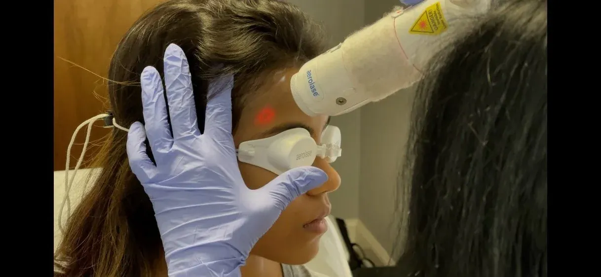 A woman wearing protective eyewear during an Aerolase facial laser treatment